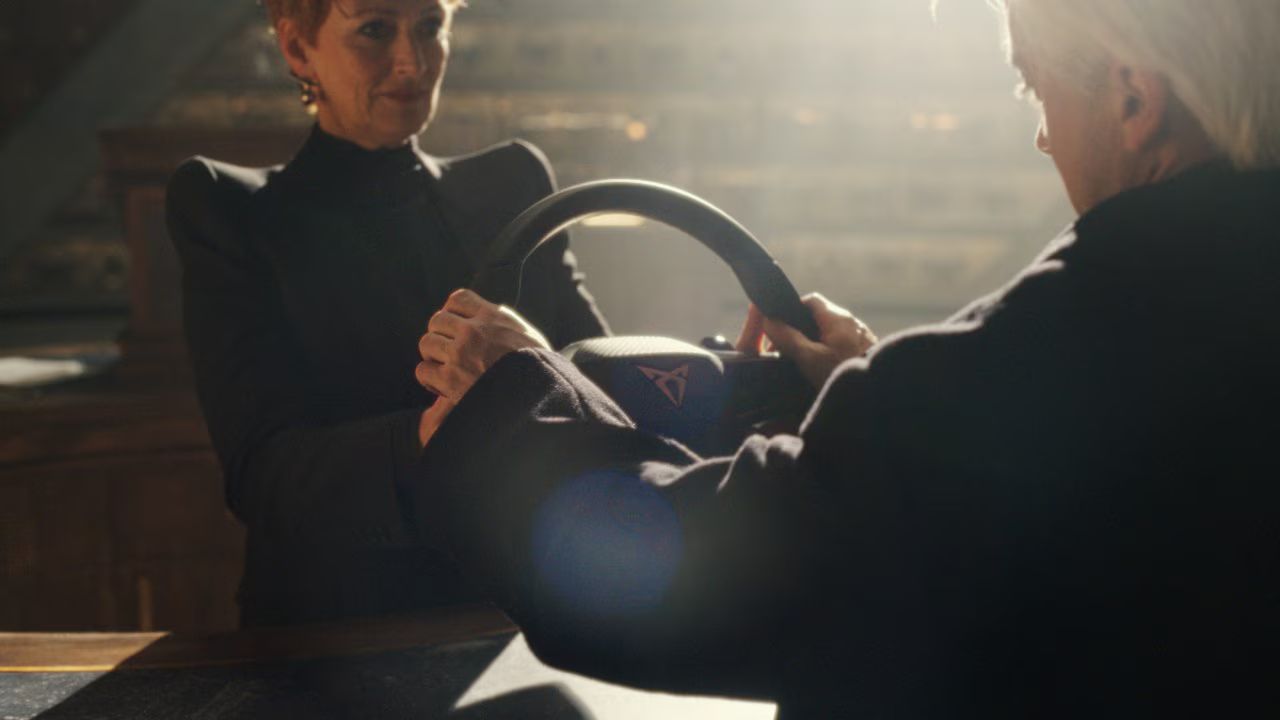 Tom Felton in druga oseba v elegantnem prostoru pregledujeta volan vozila Cupra. Prizor poudarja dizajn, izdelavo in pozornost do detajlov.