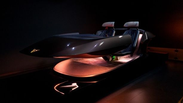 Elegantna futuristična dvoseda naprava je osvetljena na temnem ozadju. Ima aerodinamično obliko s sivimi sedeži in se zdi tehnološko napredna. Osvetlitev poudarja njene gladke linije.