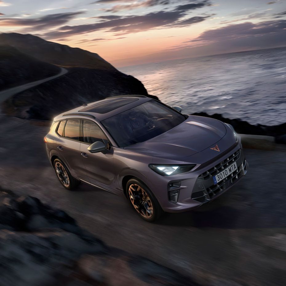 CUPRA Terramar vozi po obalni cesti ob sončnem zahodu.