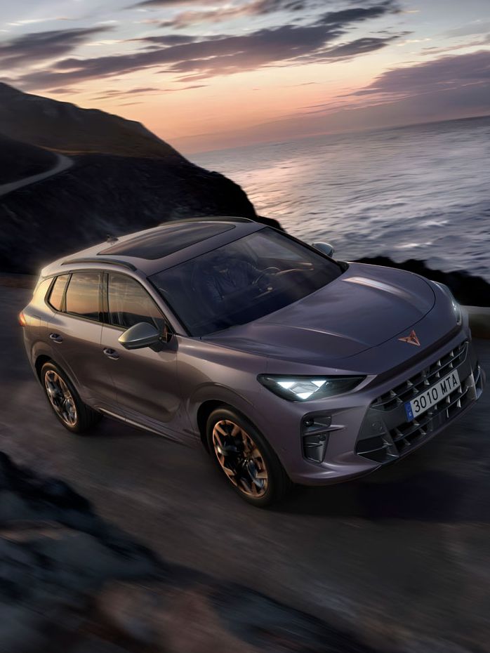 CUPRA Terramar vozi po obalni cesti ob sončnem zahodu.