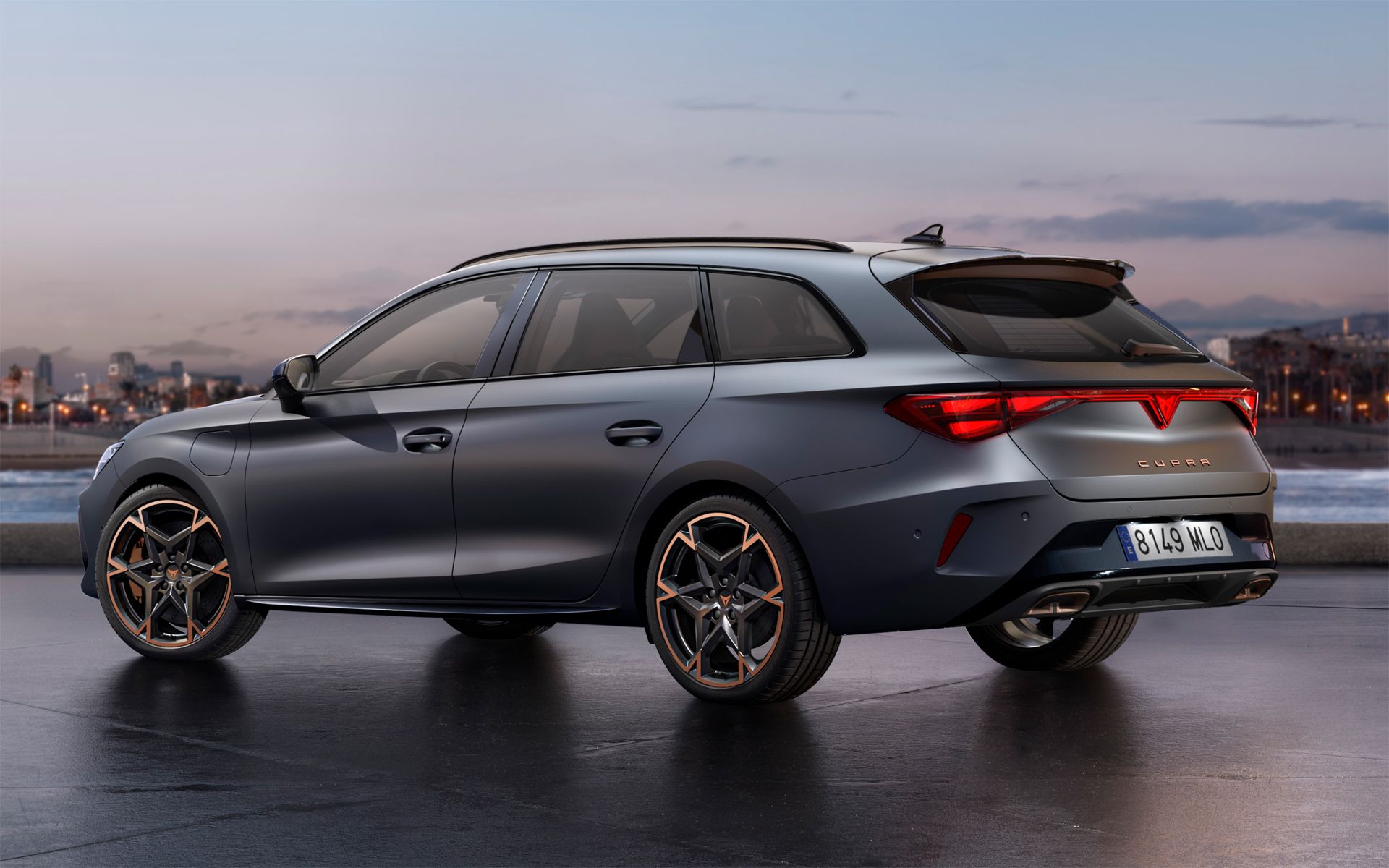 Temno siv CUPRA Leon Sporstourer je parkiran zunaj ob sončnem zahodu. V ozadju so vidni obrisi mesta.