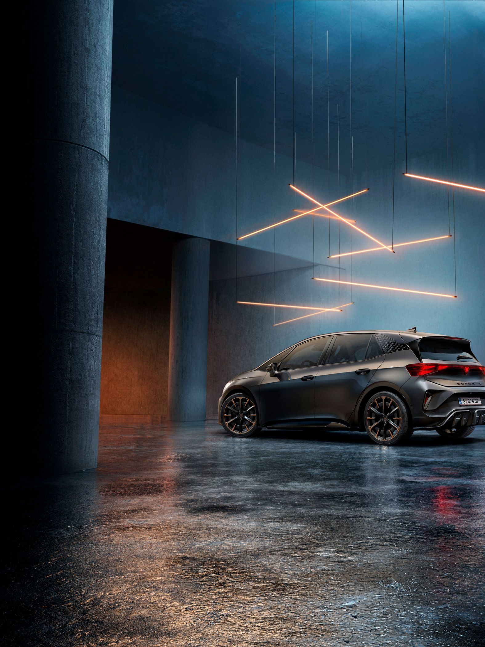 Ein CUPRA Born steht in einem stilvoll beleuchteten, industriellen Raum mit Betonwänden und -säulen. Von der Decke hängen mehrere lineare Lichtquellen, die ein elegantes Ambiente schaffen. Das Fahrzeug ist rückseitig zu sehen und reflektiert das Licht auf dem glänzenden Boden.