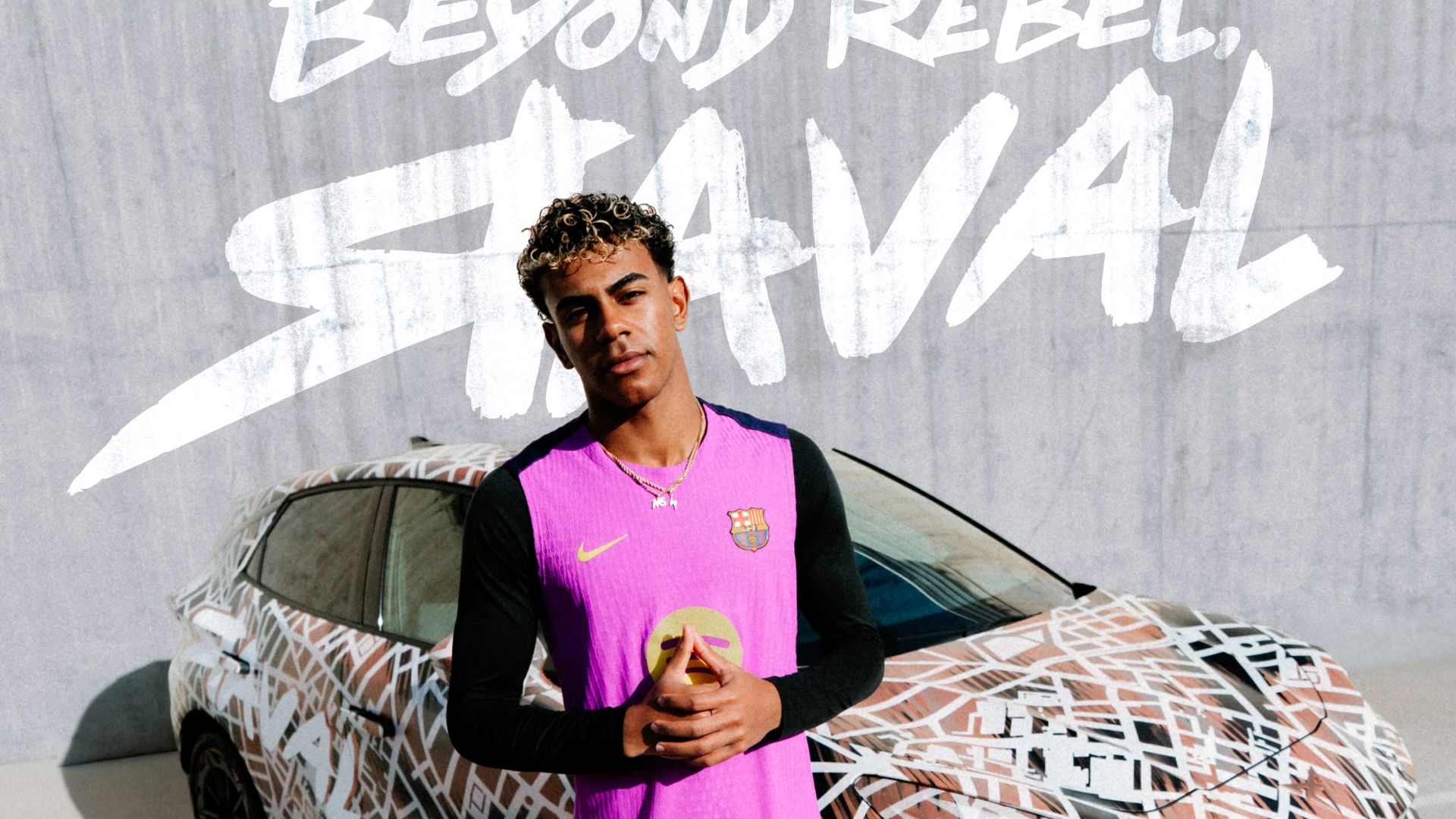 Nogometaš FC Barcelone v roza dresu stoji pred CUPRA Raval vozilom. V ozadju napis: BEYOND REBEL, RAVAL.