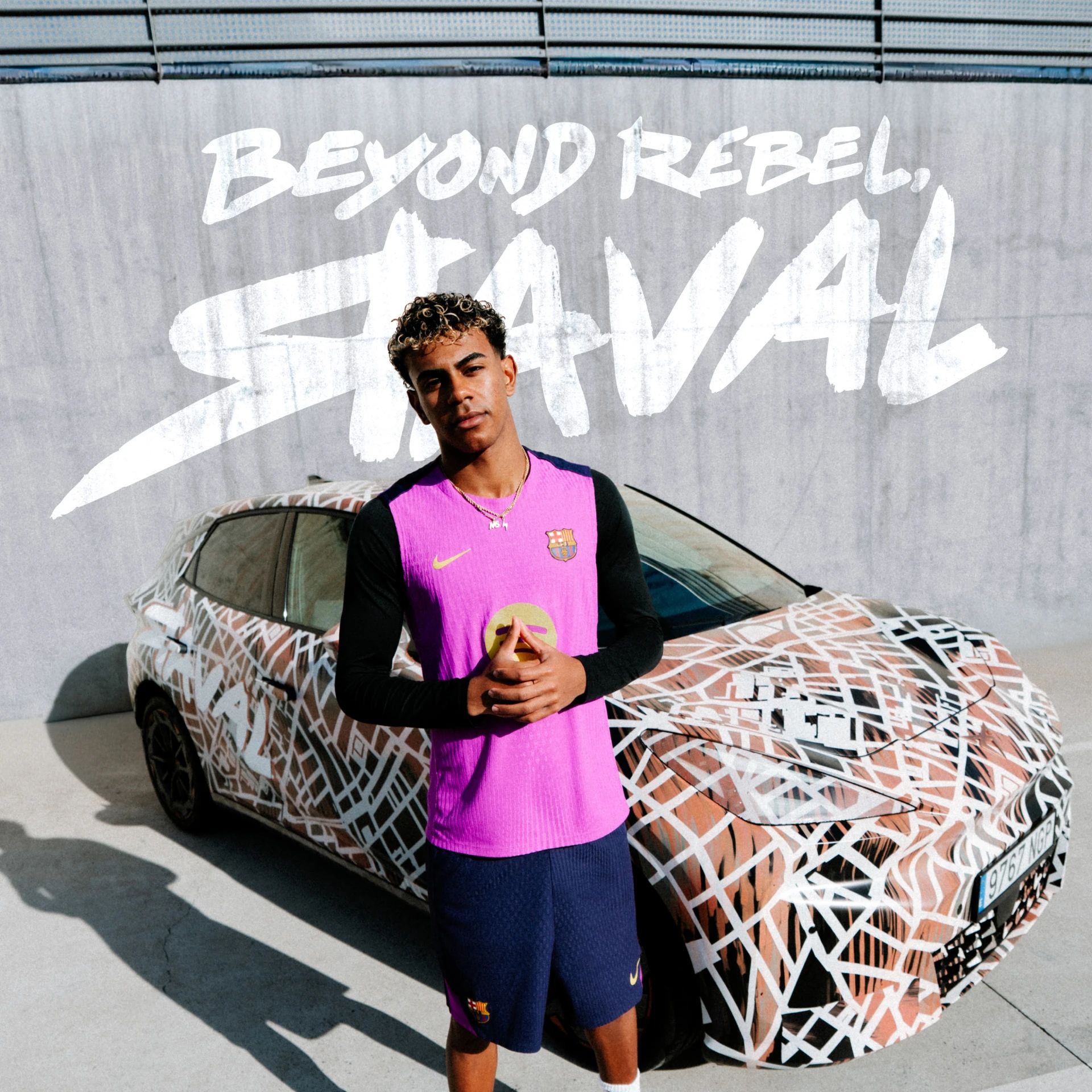 Nogometaš FC Barcelone v roza dresu stoji pred CUPRA Raval vozilom. V ozadju napis: BEYOND REBEL, RAVAL.