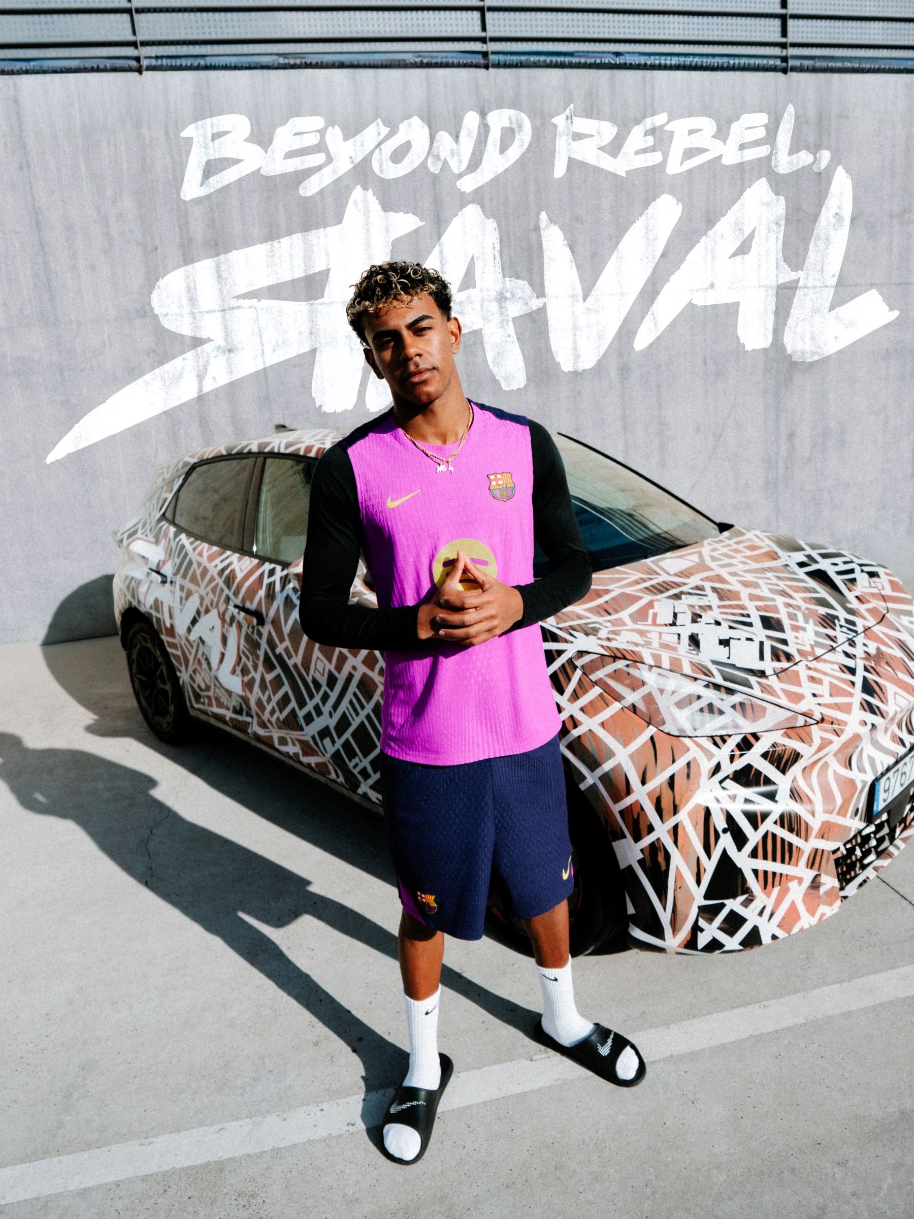 Nogometaš FC Barcelone v roza dresu stoji pred CUPRA Raval vozilom. V ozadju napis: BEYOND REBEL, RAVAL.