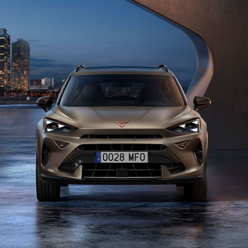 CUPRA Formentor PA je parkiran na urbanem območju z mestno panoramo, osvetljeno ob mraku.