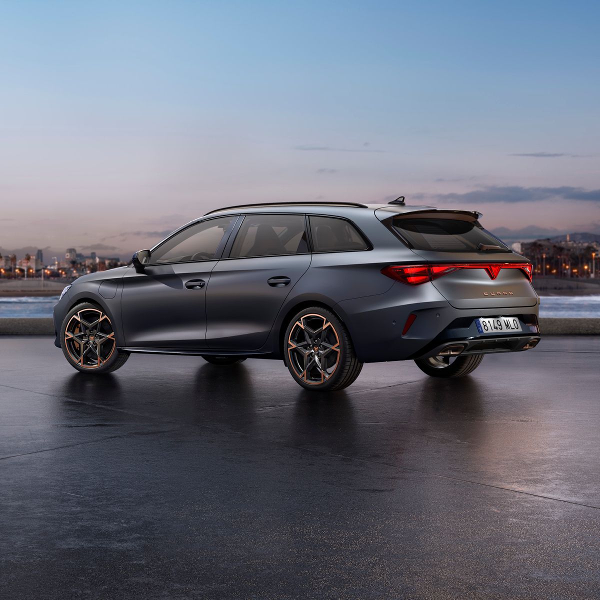 CUPRA Leon metal sive barve, parkiran na mokrem, osvetljenem urbanem območju ponoči. Avto ima ostre, aerodinamične linije.