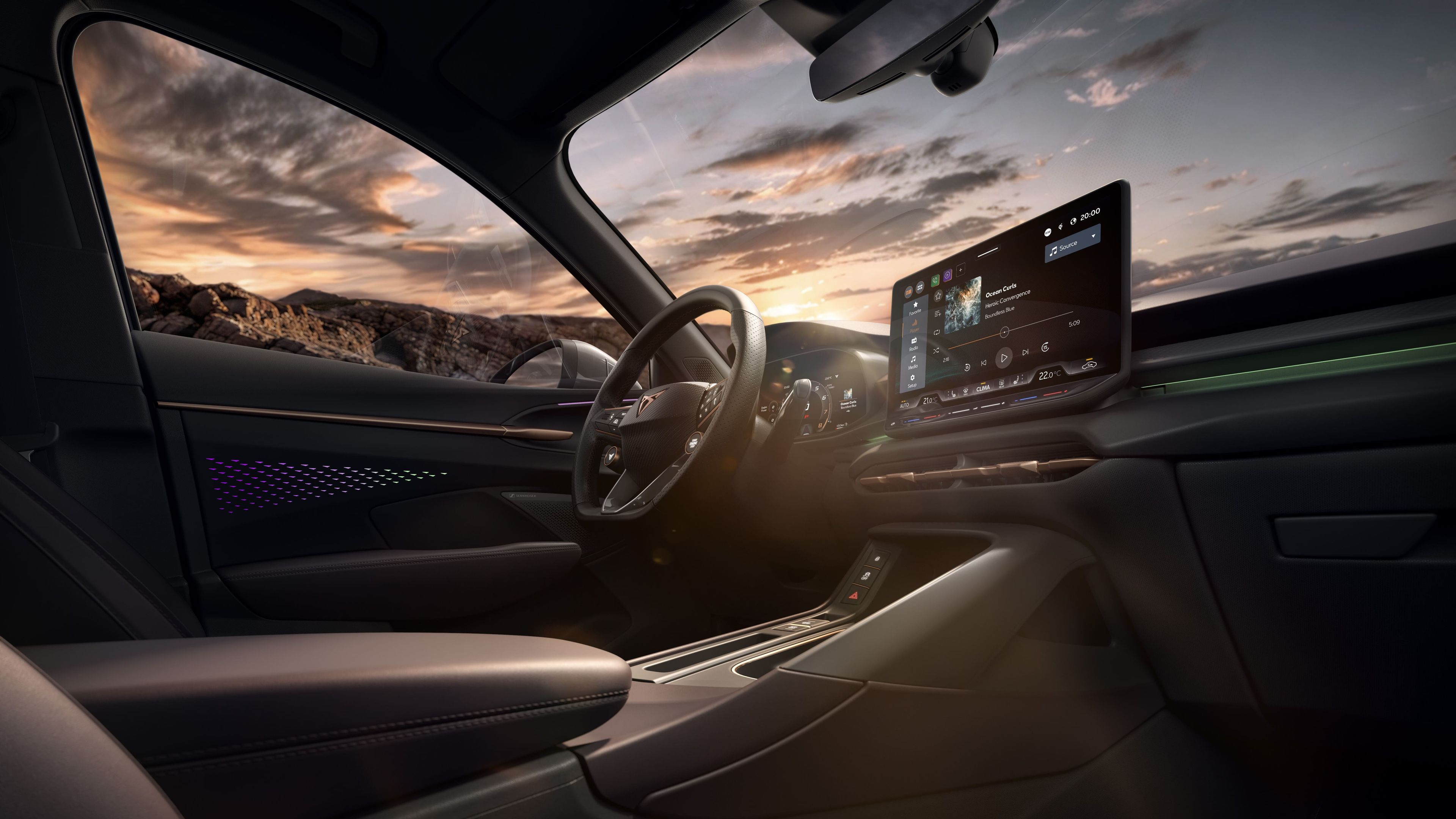 Notranjost CUPRA Terramarja ob sončnem zahodu. Osrednja konzola prikazuje zaslon na dotik z navigacijskim sistemom.