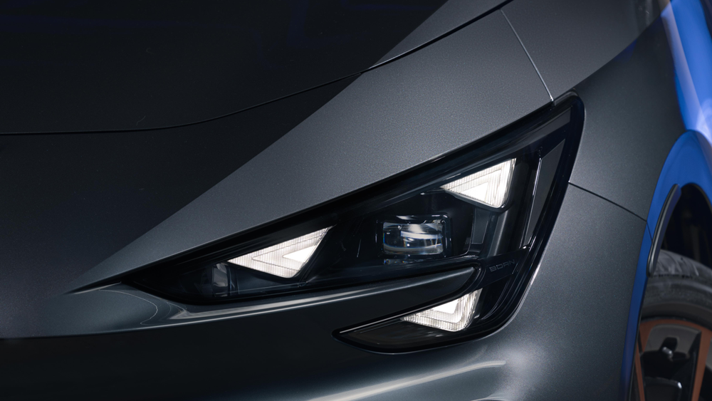 Detajl sprednjega žarometa vozila CUPRA Born VZ z izrazitim LED podpisom. Poudarjena je ostrina linij in sodoben dizajn.