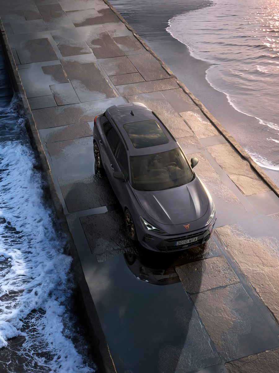 CUPRA Terramar vozi po ozkem pomolu obdanem z valovi in sončnim zahodom.