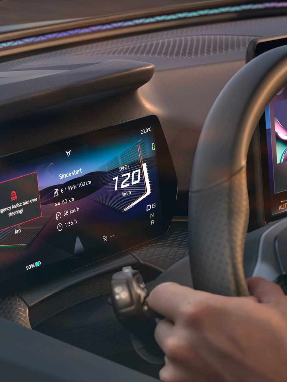 Notranjost avtomobila CUPRA Raval s sodobno digitalno armaturno ploščo, na kateri je prikazan hitrostomer z digitalnim prikazom 120 km/h ter različne informacije o vožnji. Voznik drži volan, v ozadju pa je viden še dodatni zaslon na sredinski konzoli z barvno grafiko. 