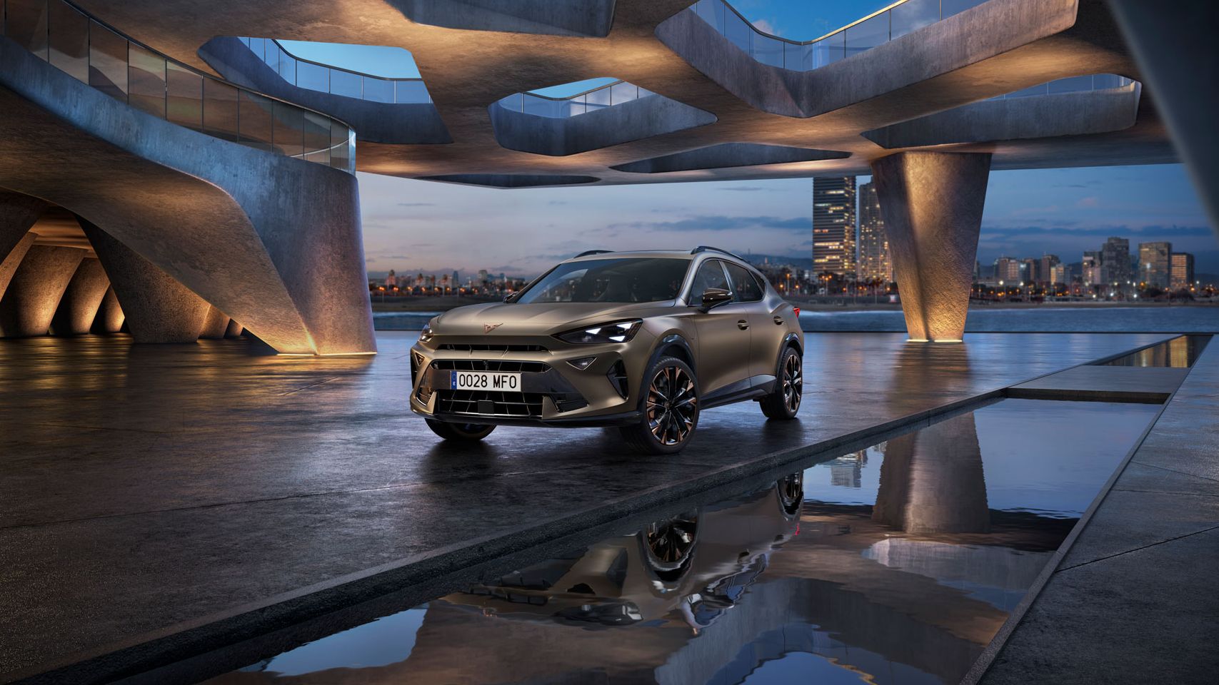 Parkiran CUPRA Formentor PA na zunanjem sodobnem parkirišču z zanimivo arhitekturo. V ozadju se vidi mestna panorama ob reki. Nebo je modro ob sončnem zahodu.