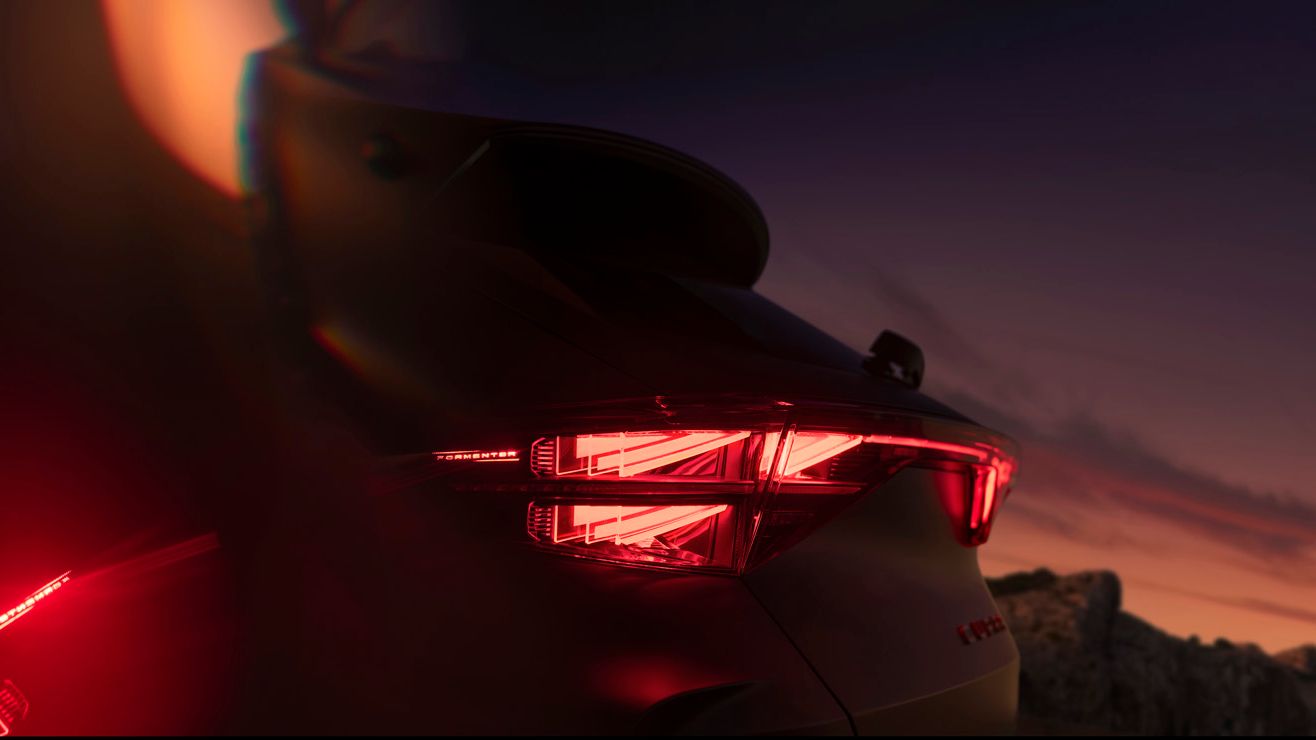 Zadnji del avtomobila Cupra Formentor z vključenimi zadnjimi lučmi v temi.