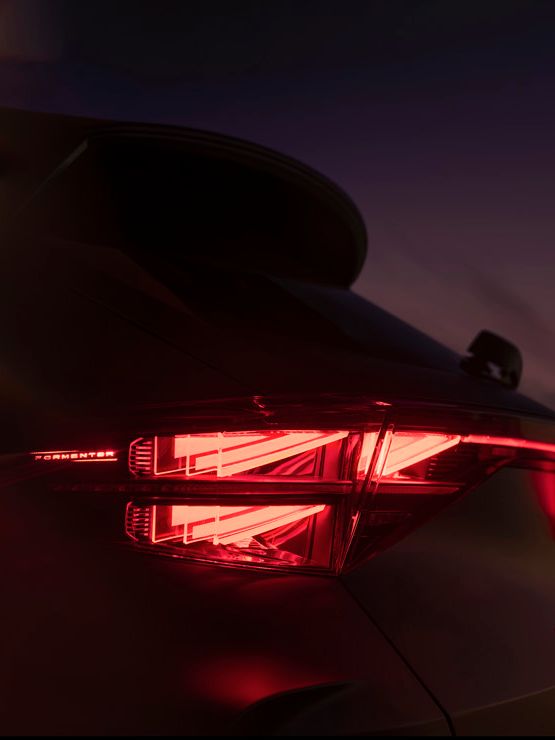 Zadnji del avtomobila Cupra Formentor z vključenimi zadnjimi lučmi v temi.