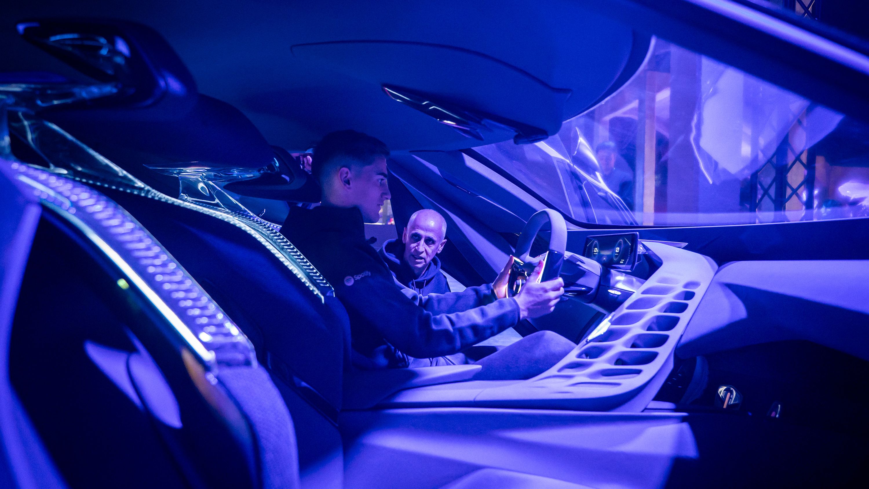 Notranjost sodobnega avtomobila CUPRA Terramar s futurističnim dizajnom. Igralec FC Barcelona sedi za volanom, okolje je osvetljeno z modro svetlobo. Elektronski instrumenti in zasloni so vidni pred voznikom.