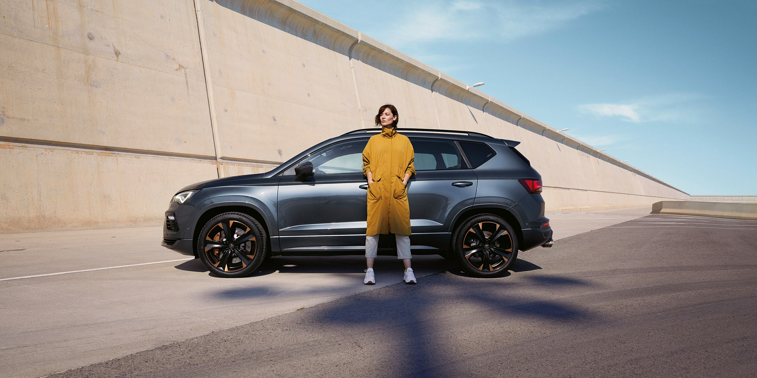 CUPRA Ateca in Grau, eine Frau steht davor