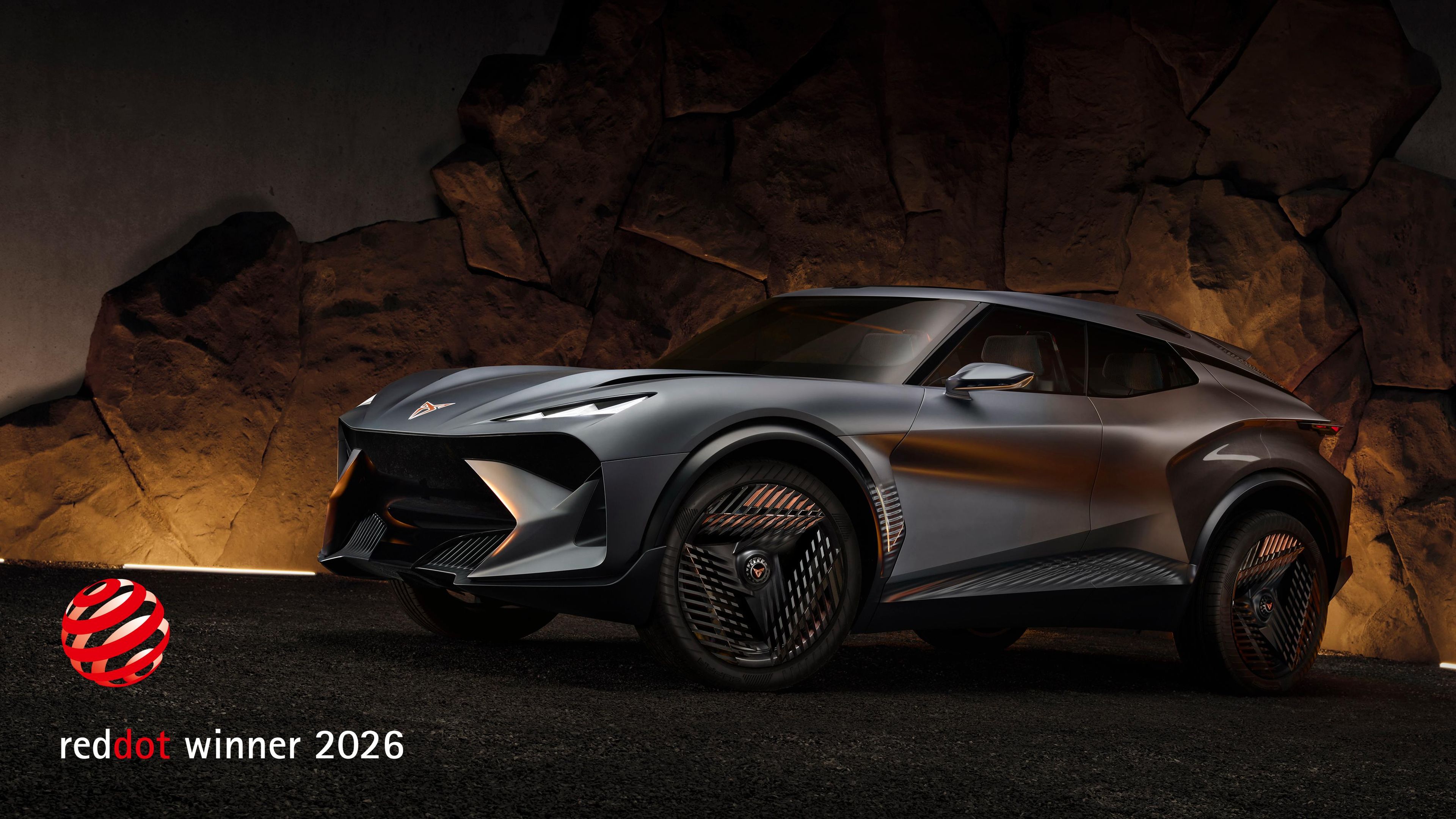 Konceptno vozilo CUPRA Tindaya je predstavljeno pred skalnato kuliso z dramatično osvetlitvijo. Oznaka »Red Dot Winner 2026« izpostavlja njegov inovativni in futuristični dizajn.