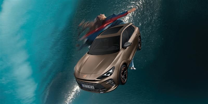 Vozilo CUPRA Terramar lebdeče v zraku z vodo v ozadju. Za vozilom pleše plesalka.