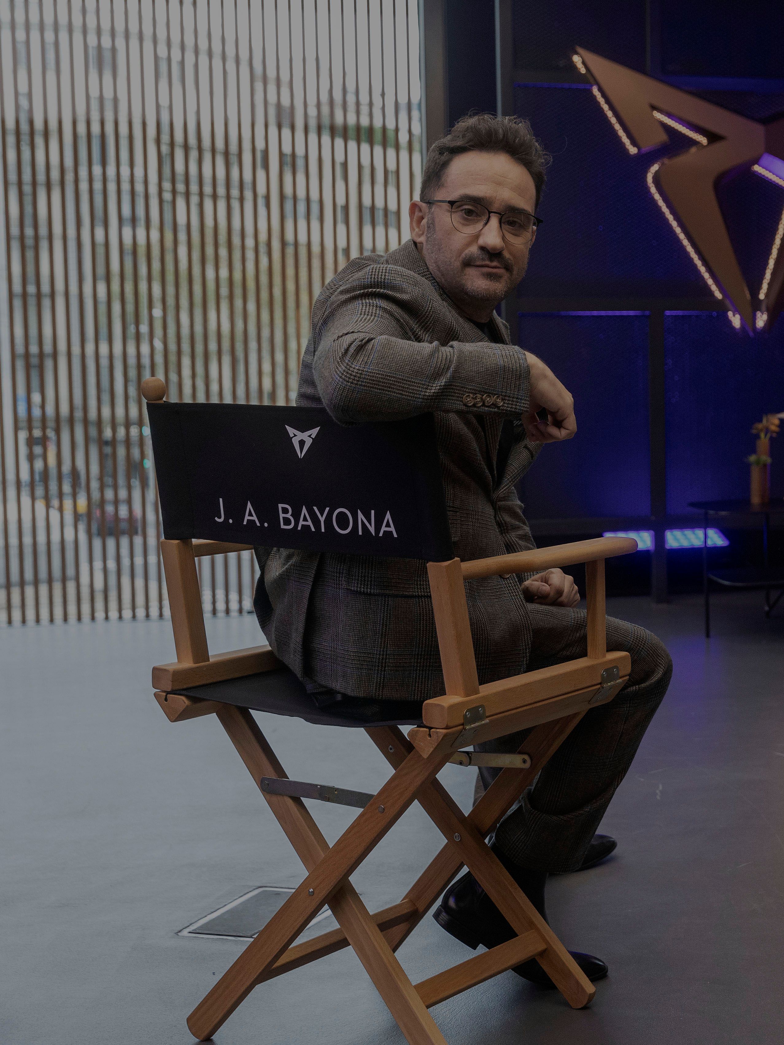 J. A. Bayona in W. Griffiths sedita na režiserskih stolih v sodobnem studiu, v ozadju pa je logotip znamke CUPRA.