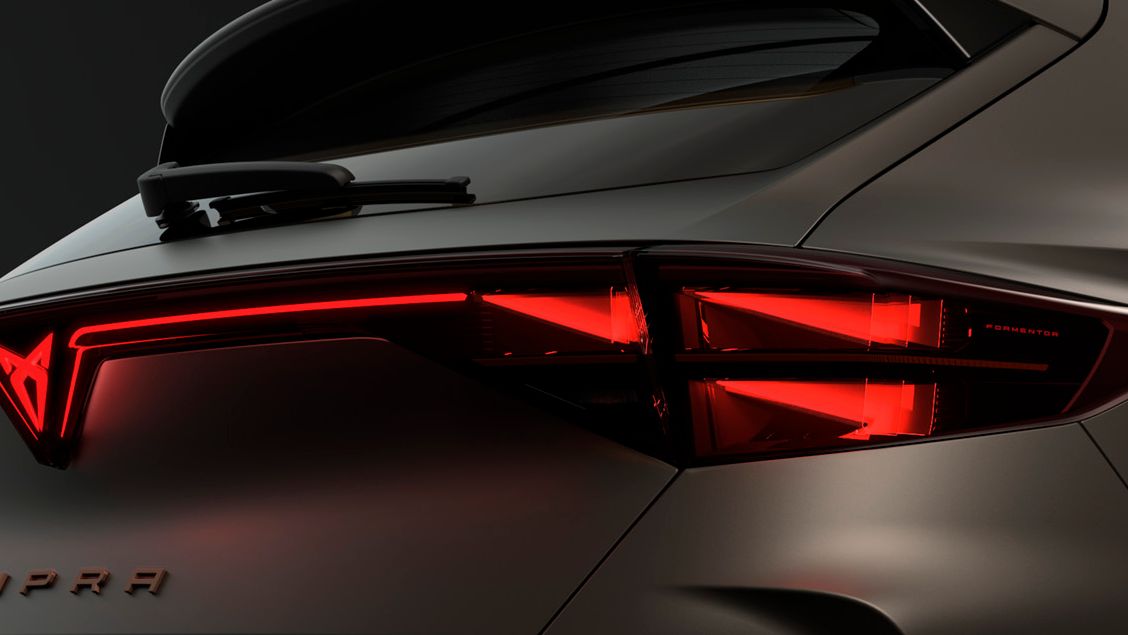 Zadnji del avtomobila CUPRA Formentor, osvetljen z rdečimi zadnjimi lučmi v temačni atmosferi.