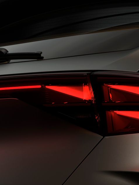 Zadnji del avtomobila CUPRA Formentor, osvetljen z rdečimi zadnjimi lučmi v temačni atmosferi.