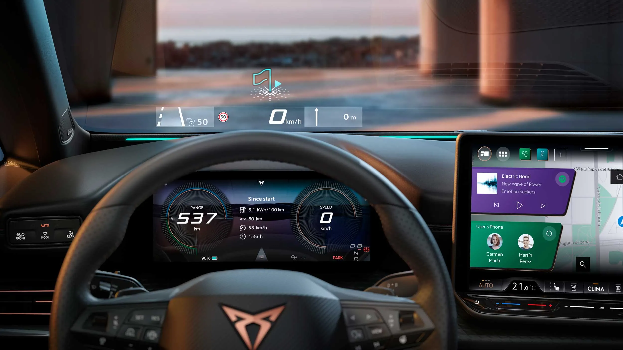 Notranjost CUPRA Borna prikazuje digitalno armaturno ploščo z barvnim merilnikom hitrosti, informacijami o vožnji in dometu. Na desni strani je velik zaslon infozabavnega sistema z glasbo in navigacijo, pred vetrobranskim steklom pa je projiciran head‑up zaslon z hitrostjo in smerjo vožnje. 