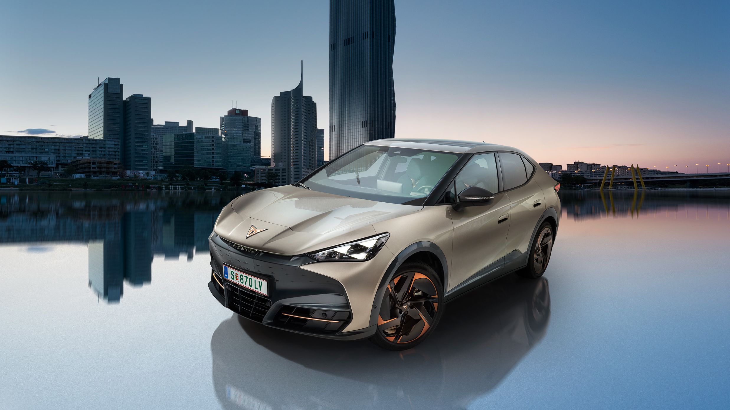 CUPRA Tavascan v barvi Atacama Beige z dunajsko Donavo v ozadju.