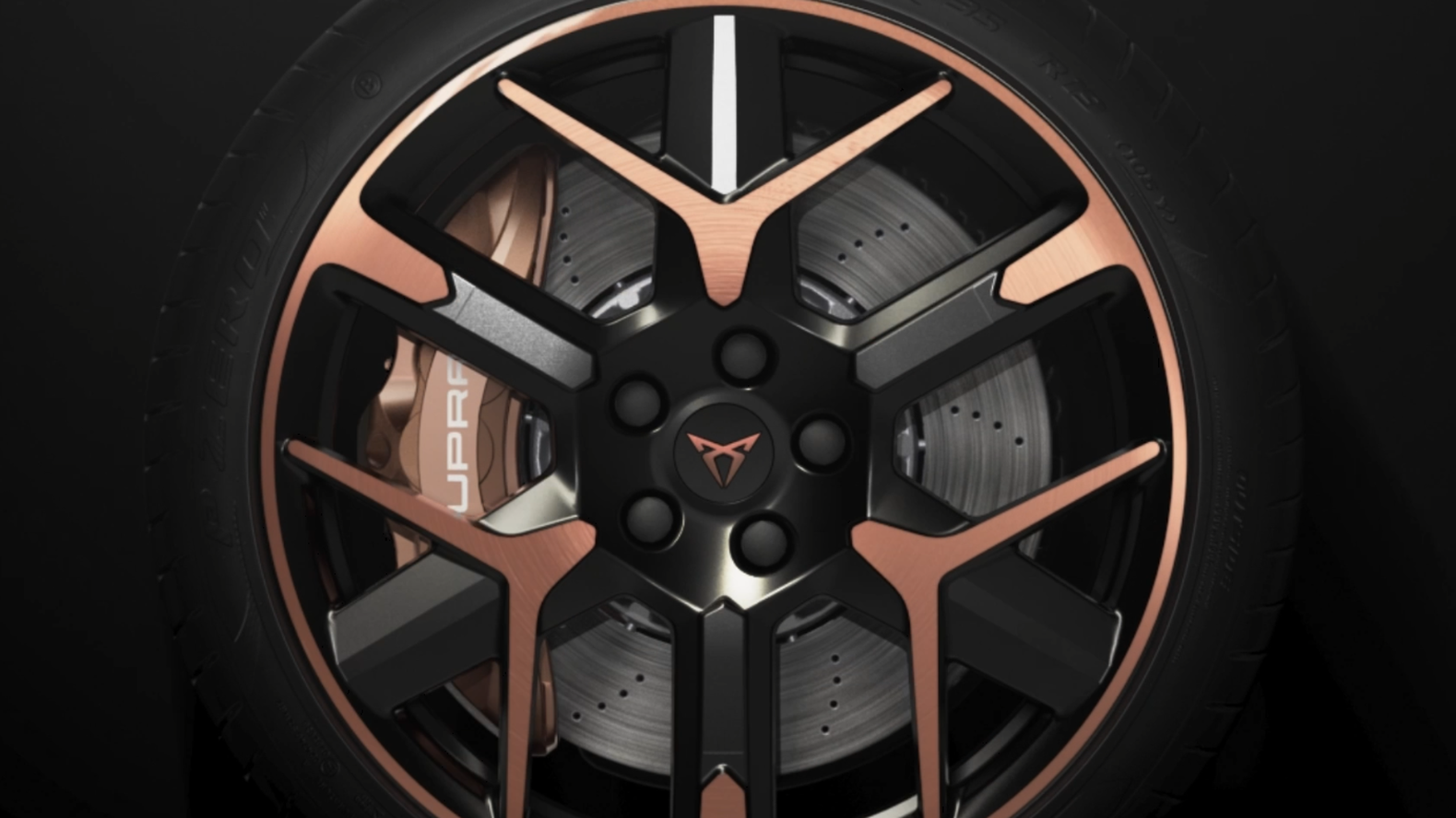 Kolo športnega Cupra Leon PA s petimi stiliziranimi kraki v črni in bronasti barvi. V ozadju je vidna velika zavorna plošča. Na kolesnem vijaku je Cupra logotip.