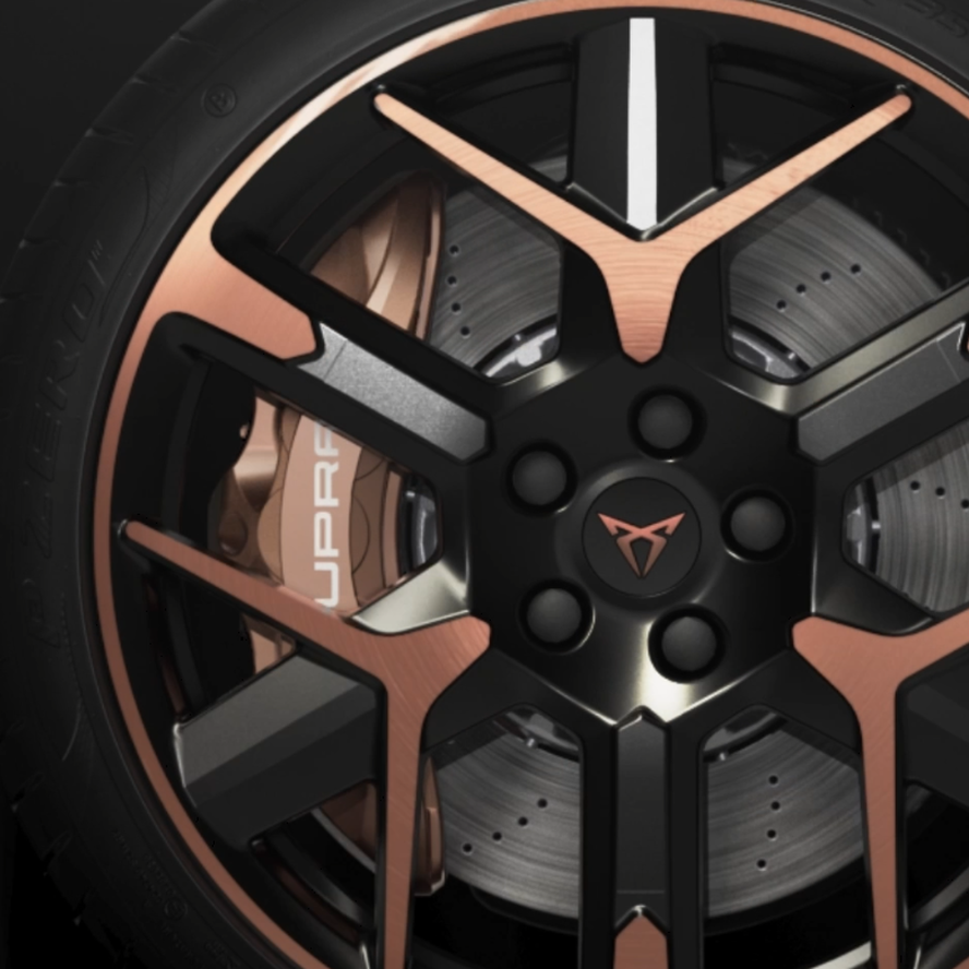 Kolo športnega Cupra Leon PA s petimi stiliziranimi kraki v črni in bronasti barvi. V ozadju je vidna velika zavorna plošča. Na kolesnem vijaku je Cupra logotip.