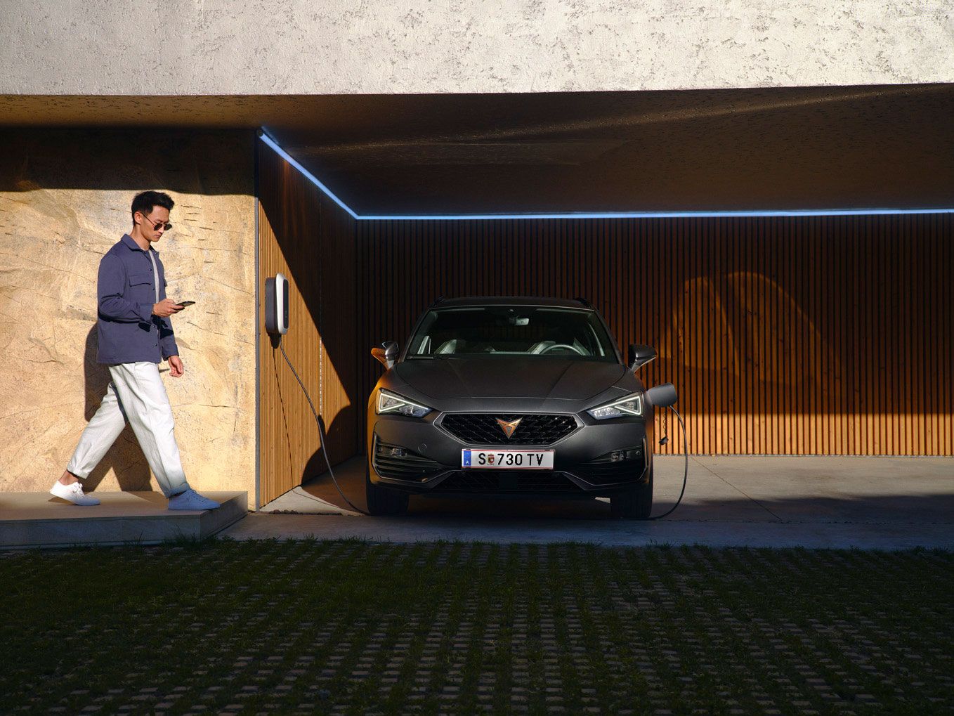 Eine Frau lehnt an einem Cupra Ateca