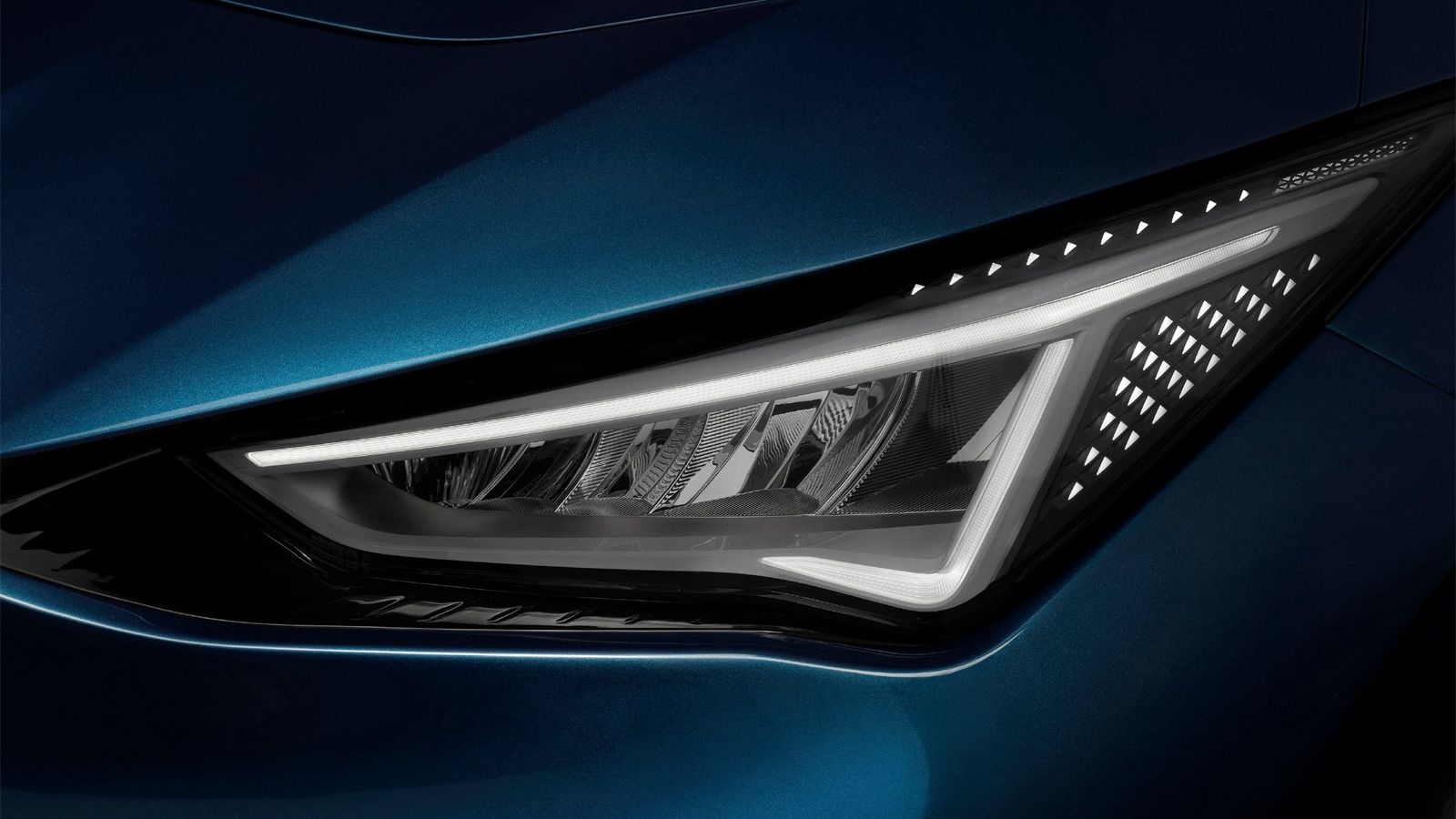 Prednji žaromet modrega avtomobila CUPRA Born, ki prikazuje sodoben in ostro oblikovan dizajn z LED osvetlitvijo.