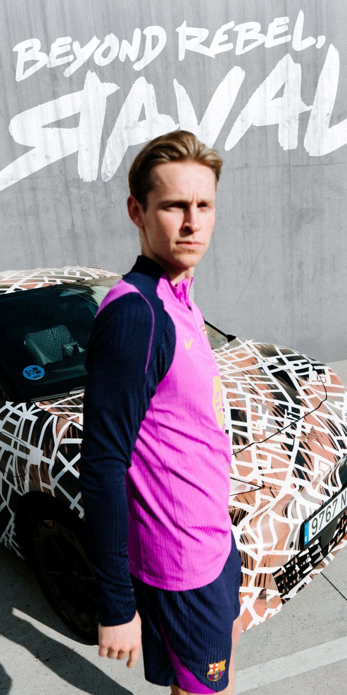 Nogometaš FC Barcelona v roza dresu stoji pred CUPRA Ravalom. V ozadju napis: BEYOND REBEL, RAVAL.