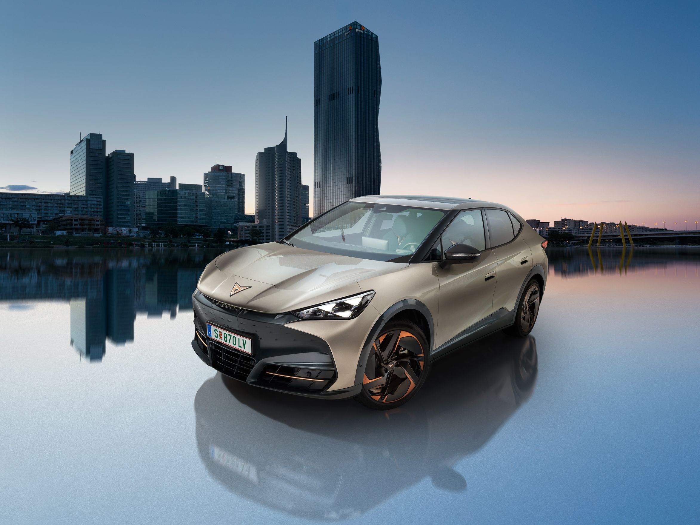 CUPRA Tavascan v barvi Atacama Beige z dunajsko Donavo v ozadju.