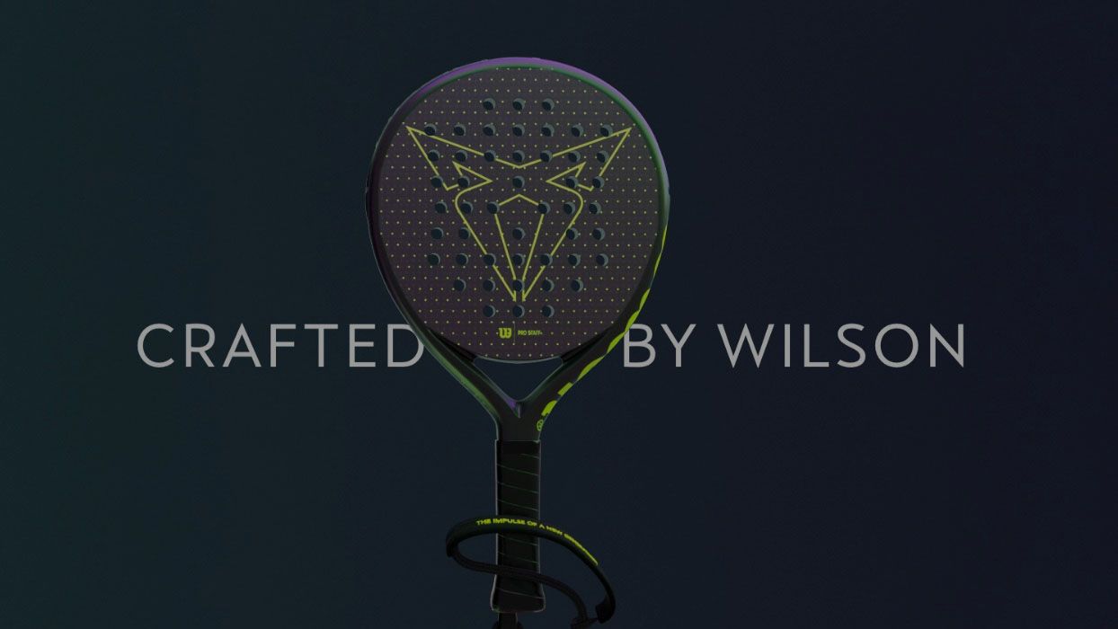 Podoba padel loparja z rumenim logotipom znamke CUPRA na črni glavi loparja. Napis "Crafted by Wilson" je prikazan na sredini slike. Ozadje je temno.