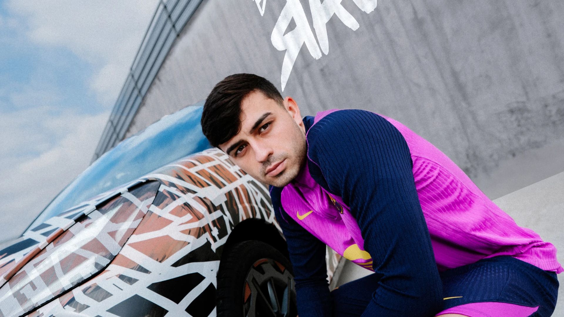 Nogometaš FC Barcelona v roza dresu pozira v počepu ob CUPRA Ravalu. V ozadju napis: BEYOND REBEL, RAVAL. 