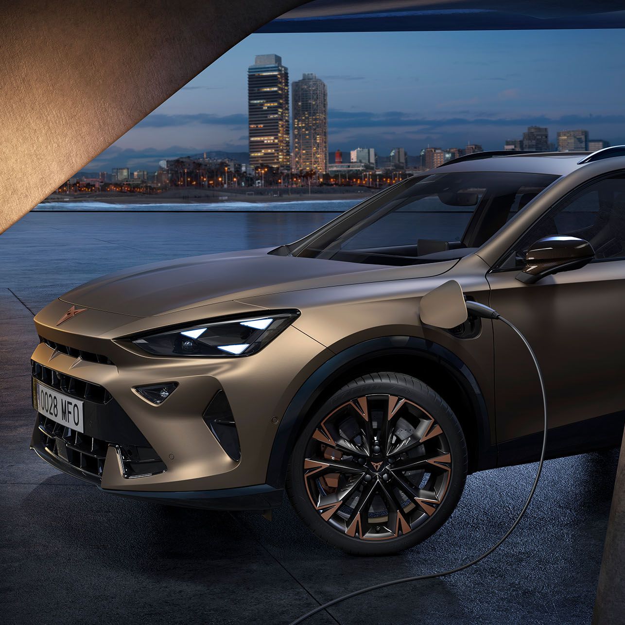 Električni Cupra Formentor se polni na polnilni postaji ob mestni pokrajini v večernih urah s svetlobo mestne obale v ozadju.