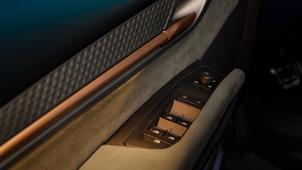 Detajl vratne obloge z vzorčastim materialom in bakrenim ročajem v vozilu CUPRA Born VZ. Poudarek je na kakovosti materialov in oblikovanju.